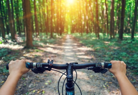 Motorized bicycle riding down a bike trail.