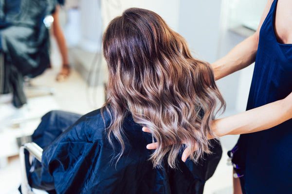 Young woman getting beautiful hairstyle in hair salon.