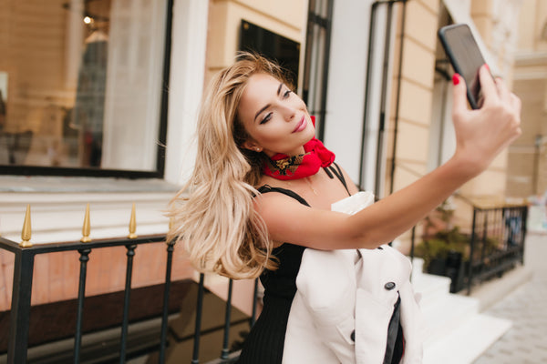 Beautiful woman smiling and taking a selfie outside. 