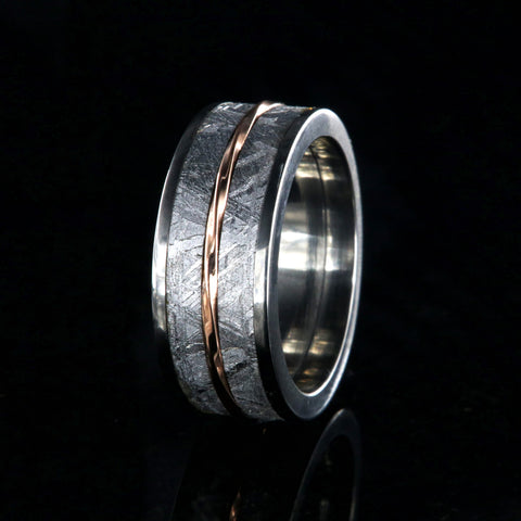 A men's meteorite wedding band with a twisted rose gold inlay