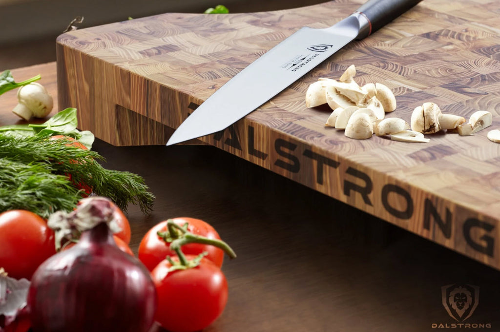 large cutting board with knife sitting on top beside veggies