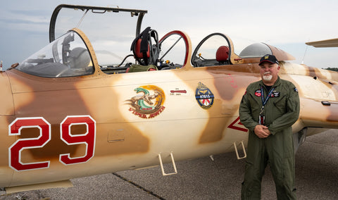 John in his flight suit standing next to a desert camo painted L-29 jet bearing a Toronto Police Service crest and Constable Andrew Hong's badge number.