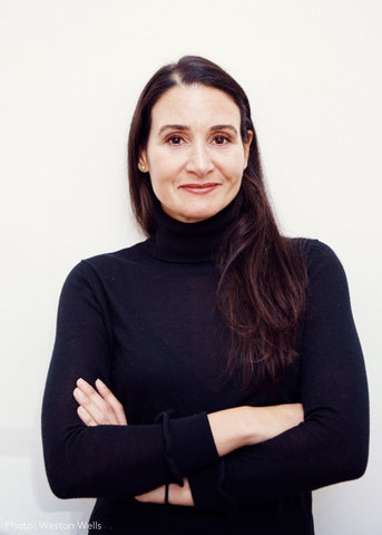 Portrait of smiling Shamara Bondaroff posing with crossed hands in a dark blue top.