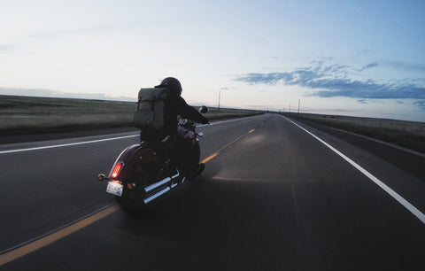 Andrew Campo riding an Indian Scout Motorcycle on a two lane highway in Kansas.