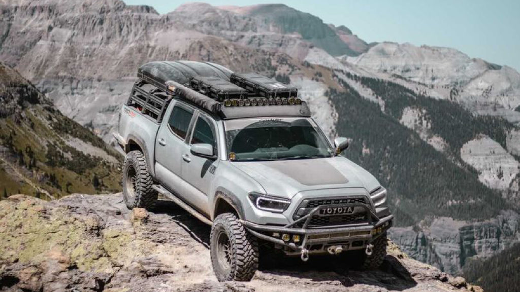 toyota tacoma sitting out mountain top with condition 1 cases attached to roof rack