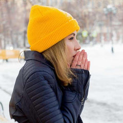 Winter Acne, young woman warming her hands in the cold