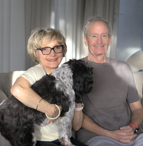 woman sitting holding a dog with man next to her