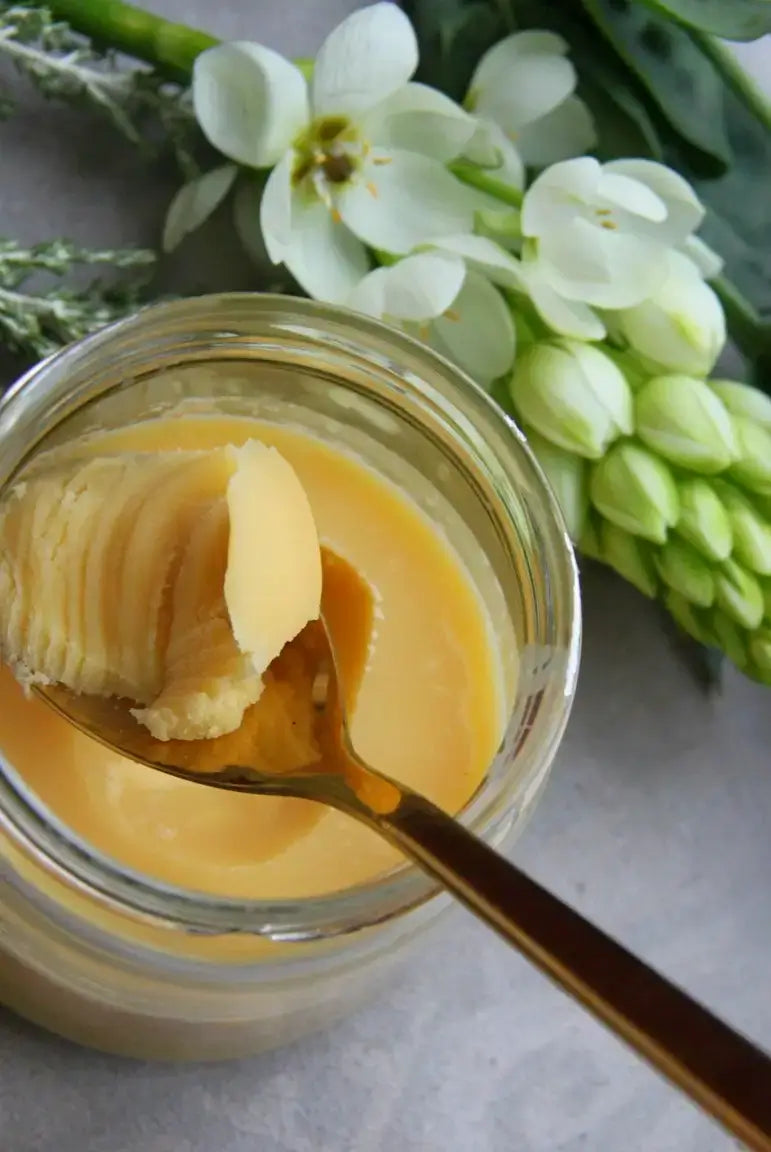Open jar of ghee with a creamy texture, as opposed to being grainy or liquid.
