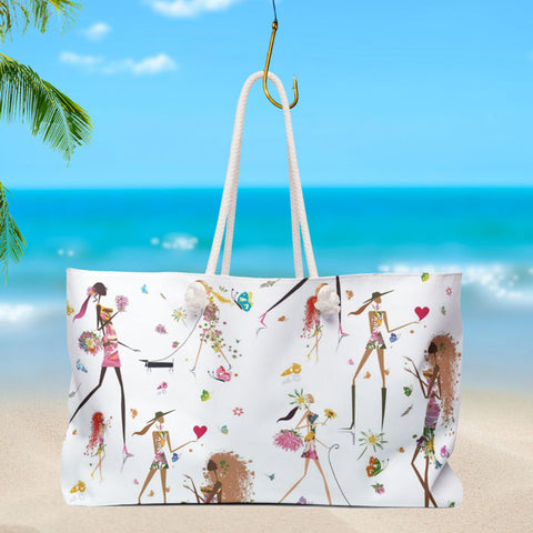 A white handbag with feminine figures in front of the beach