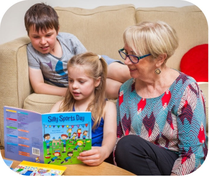 woman and two children reading together at home