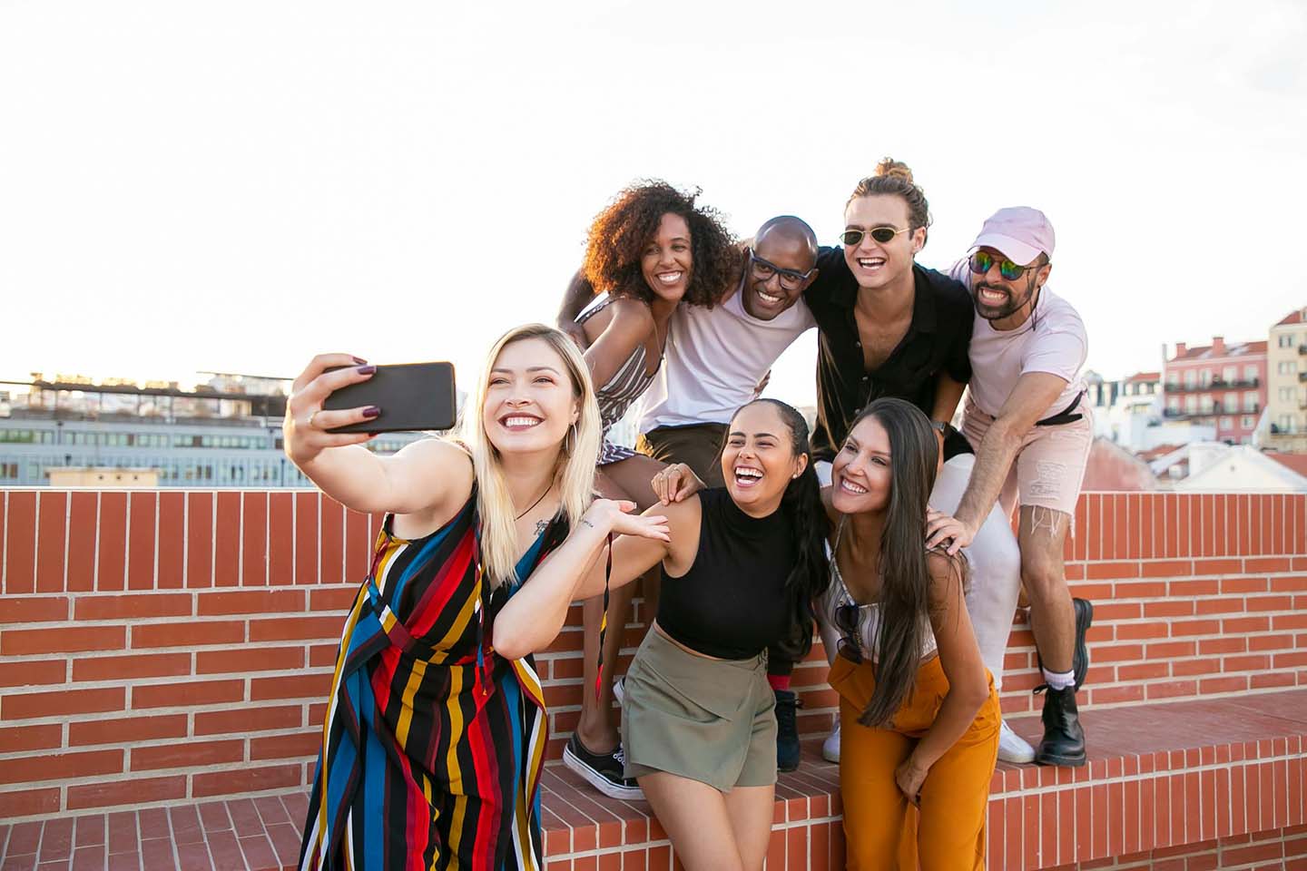 a group of friends having fun while taking a selfie at a rooftop