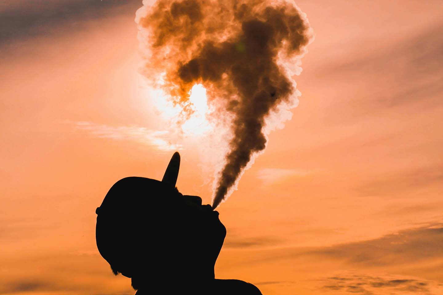 man vaping at sunset