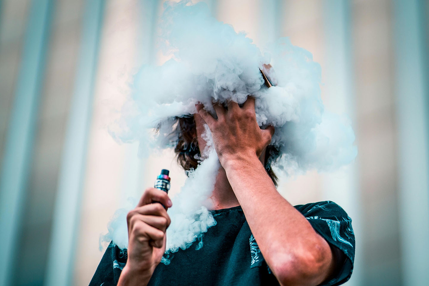 man with hand on face and big vape cloud