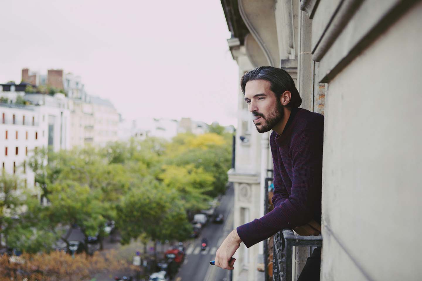 man vaping in the window during daytime