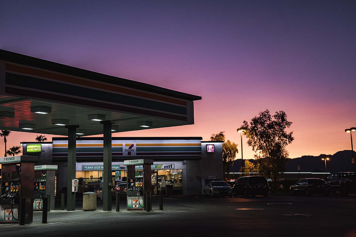 gas station with a convenience store at night with a sunset in the background