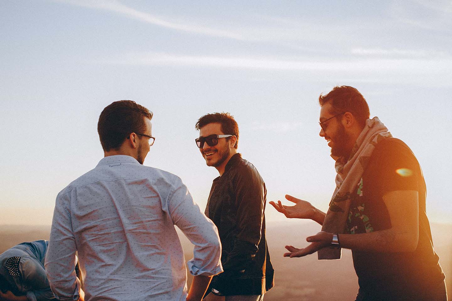 Friends laughing outside at sunset