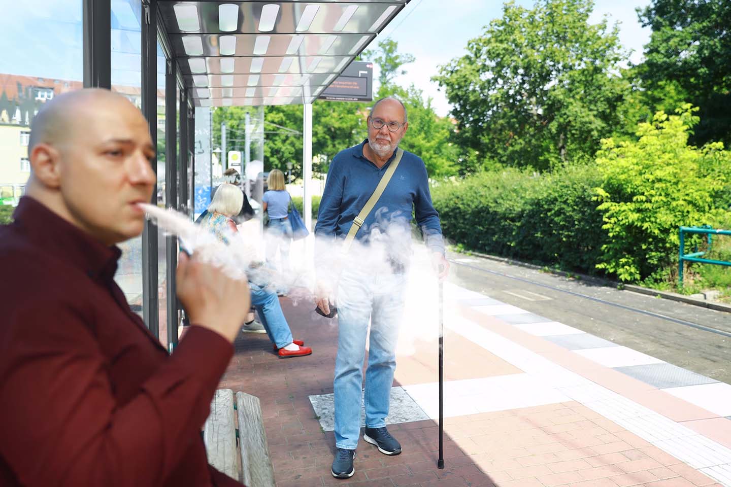 Man looking at another man vaping