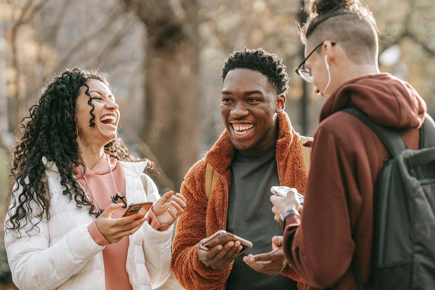 Three friends laughing outside