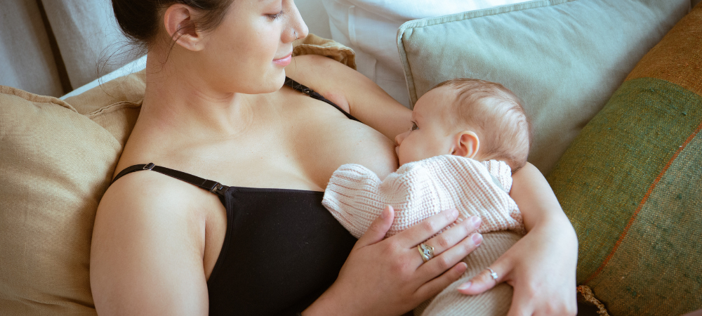 Breastfeeding Mother feeds her child while wearing a nursing bra