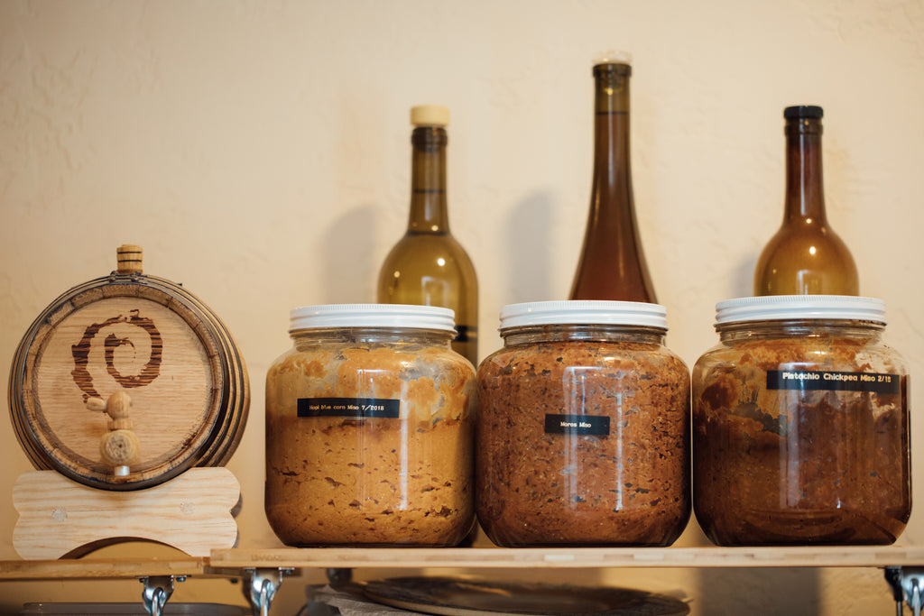 Three large jars of various handmade misos in Daniel Benhaim's kitchen. 