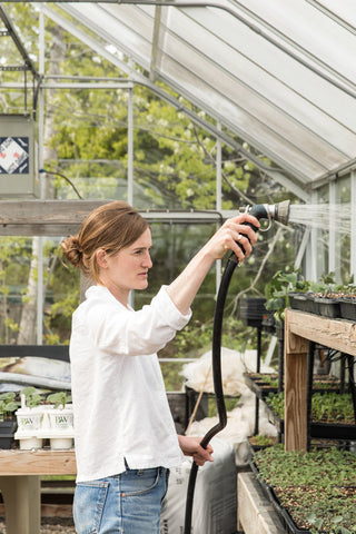 Annemarie Ahearn waters seedlings in the greenhouse at Salt Water Farm