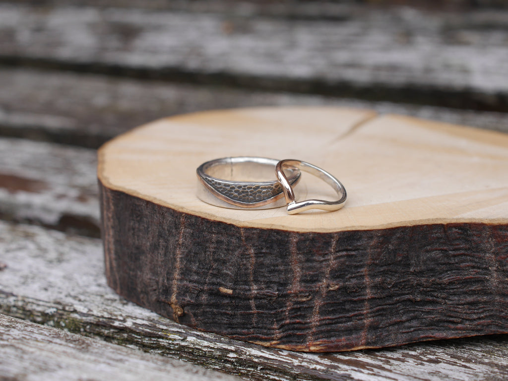 Two beautiful wedding rings made mainly from white gold with a polished and a hammered finish.