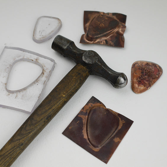 Acrylic press forming tool, copper samples and vintage hammer all part of the process of making the necklace