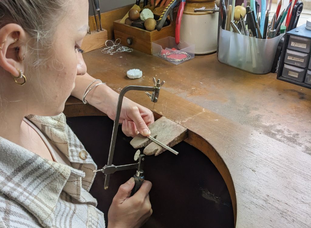 Chloe using the piercing saw to cut the wire to the correct length.
