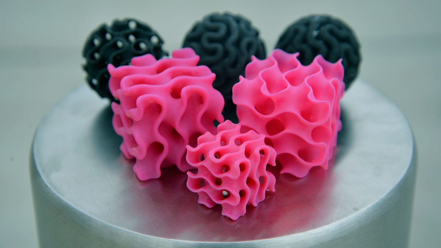 Pink and grey spheres and cubes printed with the gyroid pattern