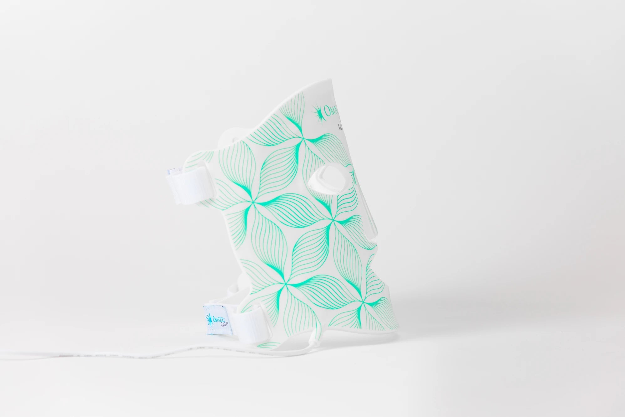 Aquatic-themed medical brace with green leaf pattern and white straps against a plain background.