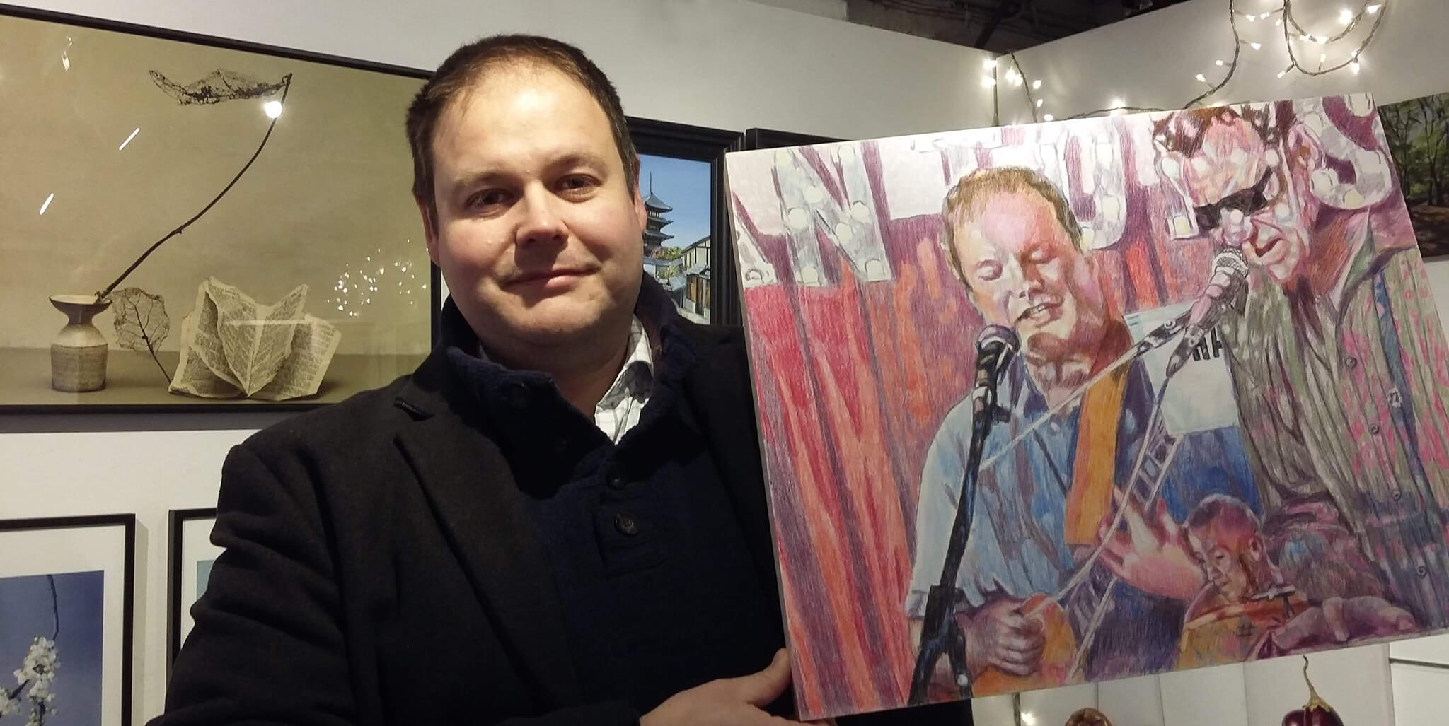 Jase Biggs of The Phantoms with Stella Tooth's portrait of him playing the Half Moon Putney at Skylark Galleries at Skylark Galleries. 