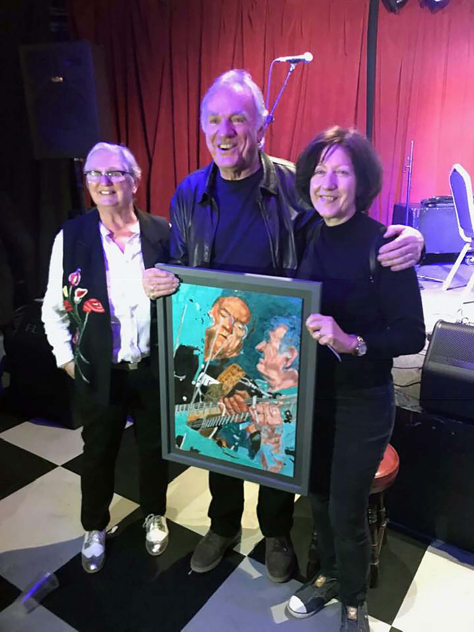 Ralph McTell with buyer of Stella Tooth on right's drawn portrait on paper of him in action at Half Moon Putney. 