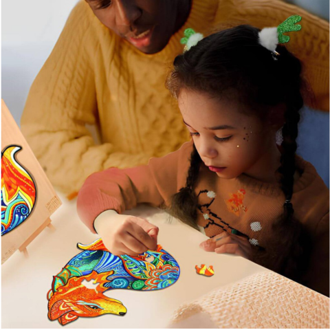 Father and daughter making a fox wooden puzzle at a table