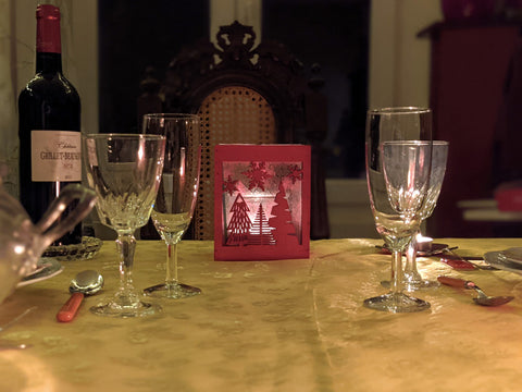 Porte-bougie rouge en bois avec des motifs de Noël sur une table de Noël décorée
