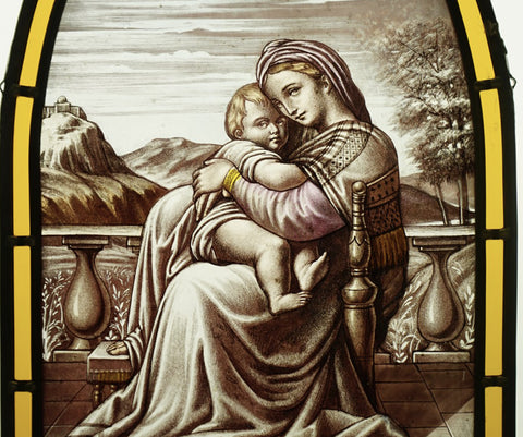 La Vierge Marie et son enfant Jésus, représentés sur un vitrail en grisaille