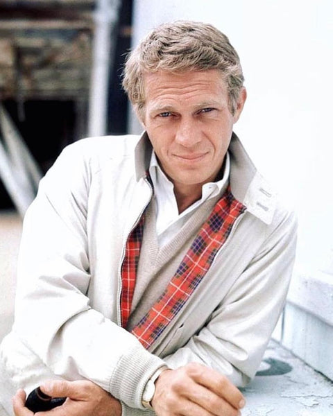 Steve McQueen wearing a white OCBD shirt, cream baracuta jacket and deep v-neck sweater