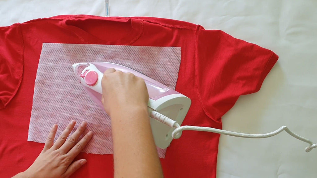 Applying no mesh fusible stabilizer on red t-shirt for embroidery machine, apply stabilizer with iron