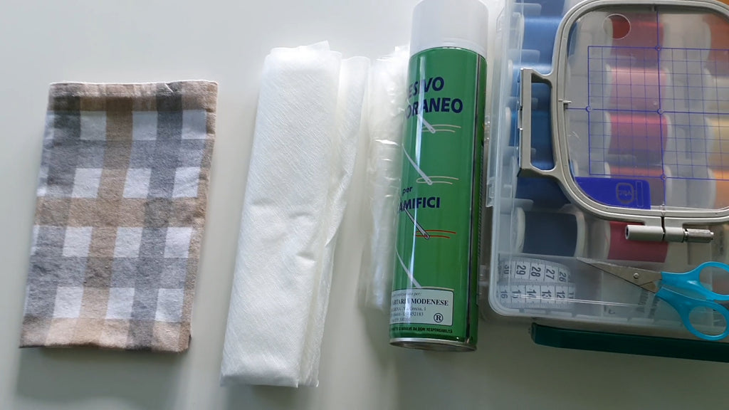 Supplies for kitchen towel embroidery: towel, wash away stabilizers, adhesive spray, threads and marking tools