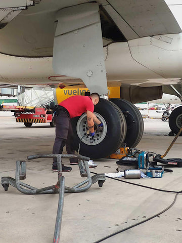 Marcelo changing a tire on an airplane, becoming an aircraft maintenance engineer in the U.K.