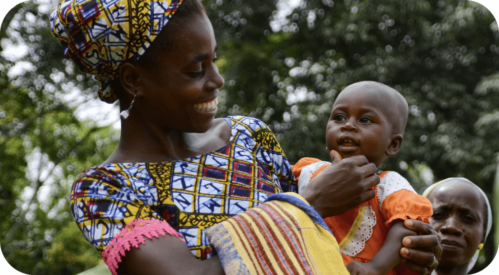 Frau in traditionellem Gewand und Kind in Ruanda lächeln