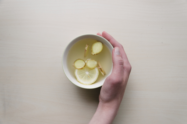 Ginger Lemon Tea In Cup With Hand Holding It