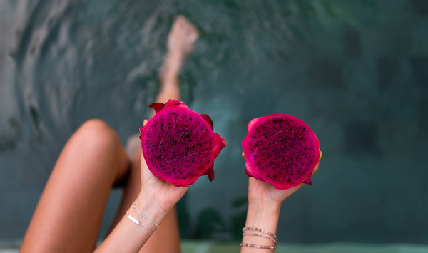 Woman Holding Bright Pink Pitaya Dragon Fruit Cut In Half