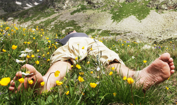 Person Laying Barefoot In The Grass Grounding For Health Benefits