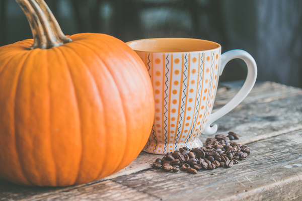 Orange Pumpkin Mug and Organic Coffee Beans on Wood Table for Making Clean Lattes