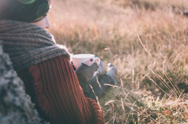 Woman Enjoying a Pumpkin Spice Latte Outdoors during the Fall Season