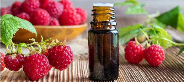 essential oil bottle with red raspberries