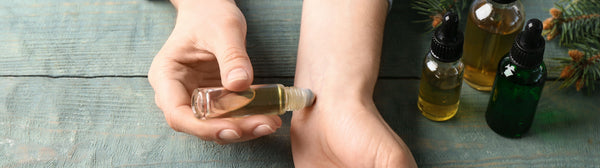 hands applying essential oils with rollerball