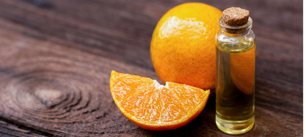 orange oil in bottle with oranges