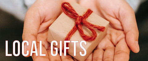 Image of a hand giving a present with the text Local Gifts