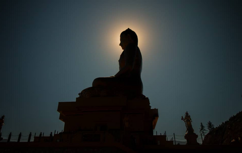 Buddha Statue with the sun behind it